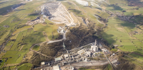 This image: an aerial photograph of Hope Cement Works taken in 2022.
							 The map: the map shows the blue boundary of Breedon's ownership area at the site, including the 
							 site of the former pumping station in Bradwell, Eden Tree Caravan Park, and the existing rail 
							 connection around the northwest of Hope.